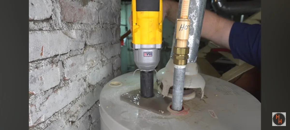 A long internal rod being removed from a storage water heater