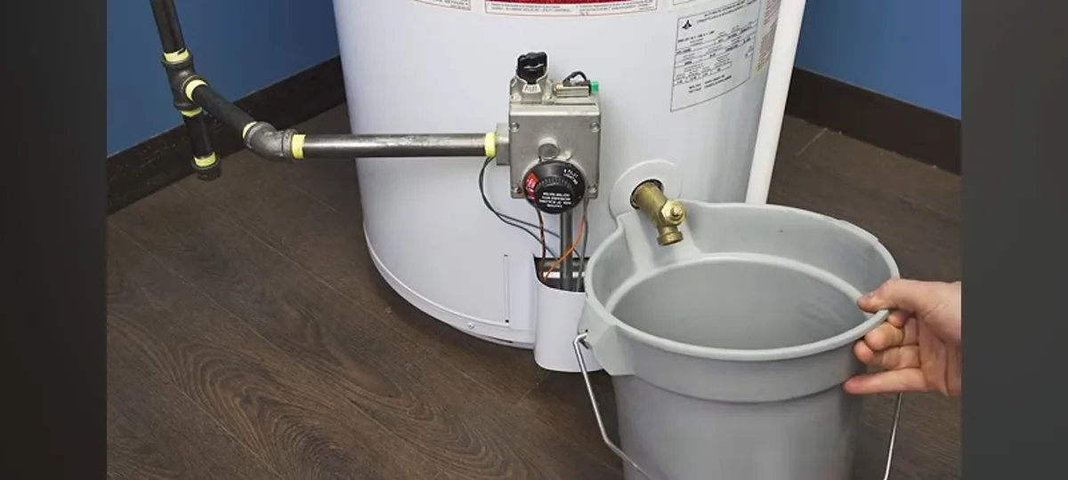 A bucket positioned beneath a storage water heater drain valve