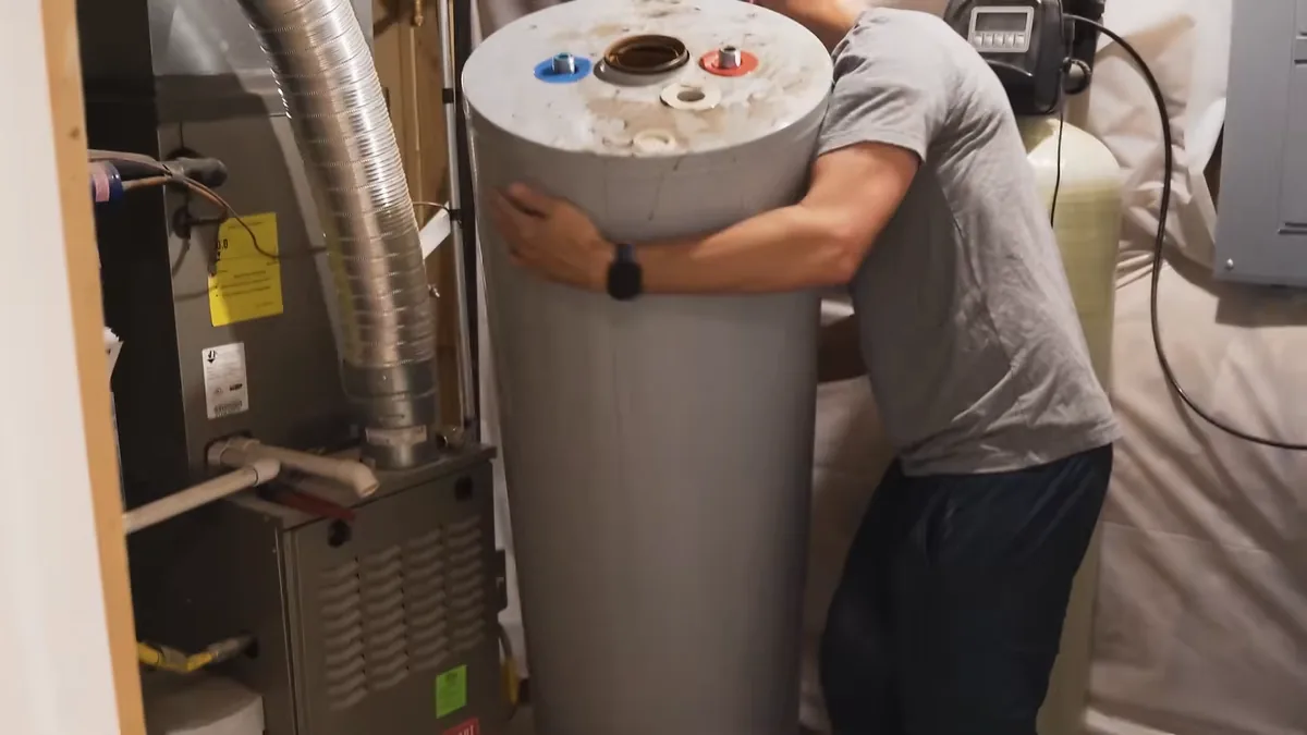 A storage water heater being moved during replacement work