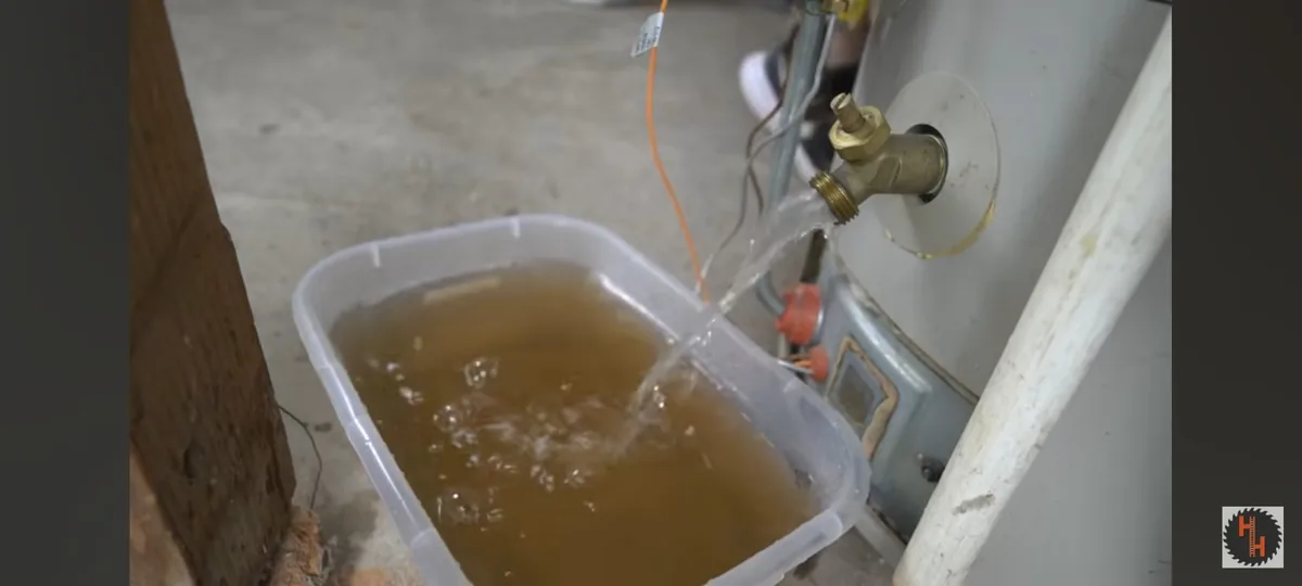 Sediment-colored water collected in a bucket beneath a heater