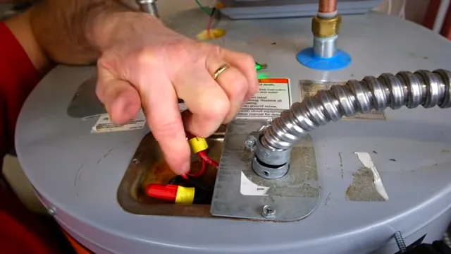 Hands inspecting the connections at the top of a storage water heater